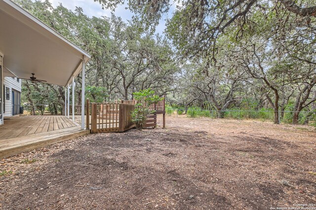 view of yard featuring a deck and ceiling fan