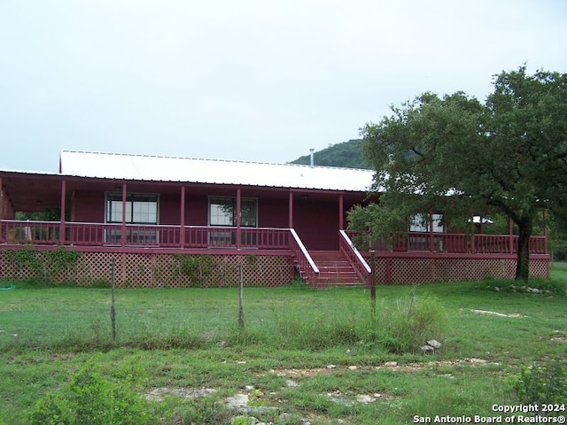 view of front of home with a wooden deck and a front lawn