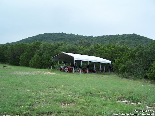 view of yard with a carport and a mountain view