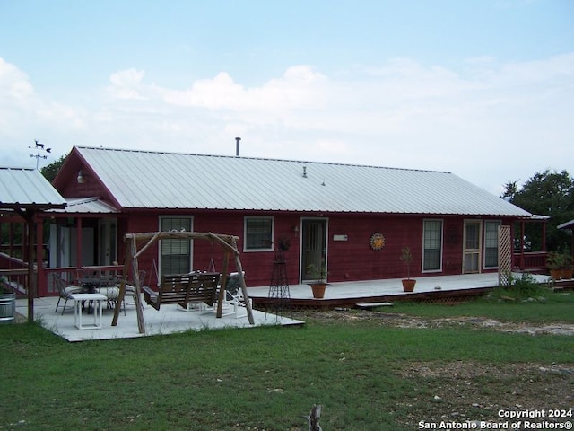 back of property featuring a patio area and a lawn