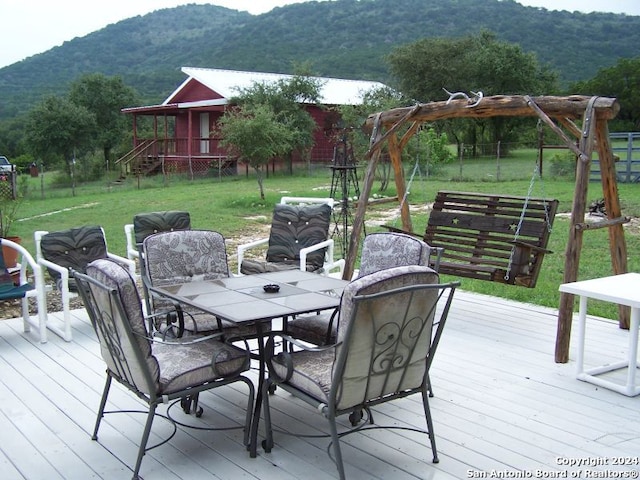 deck with a mountain view and a yard