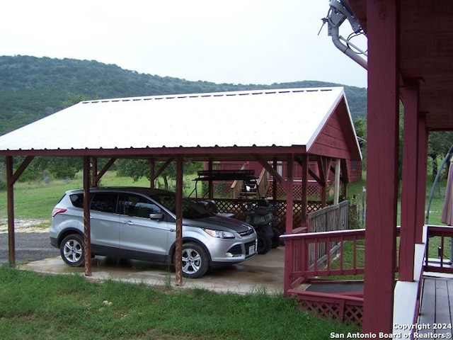 view of vehicle parking with a mountain view and a carport