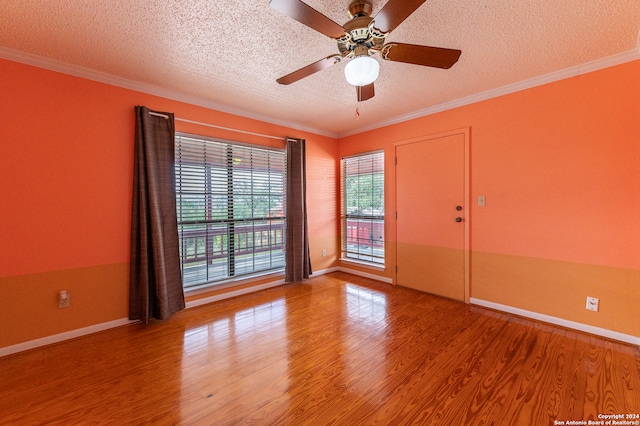 empty room with wood-type flooring, a textured ceiling, ceiling fan, and ornamental molding