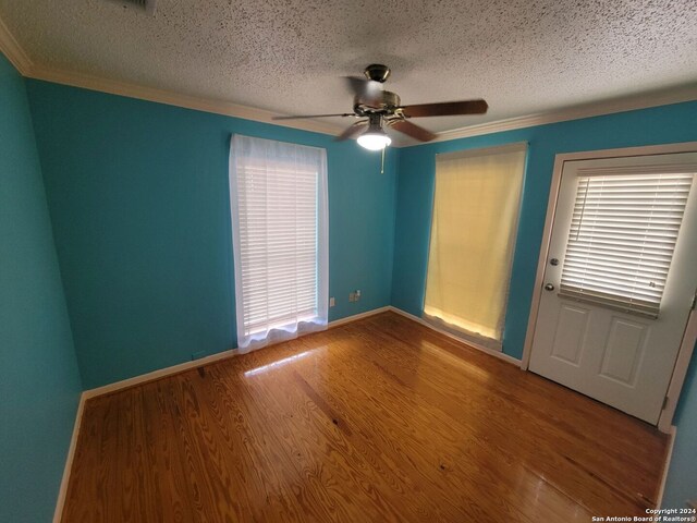 unfurnished room with a textured ceiling, hardwood / wood-style flooring, ceiling fan, and ornamental molding