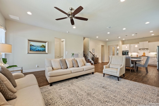 living room featuring ceiling fan and dark wood-type flooring