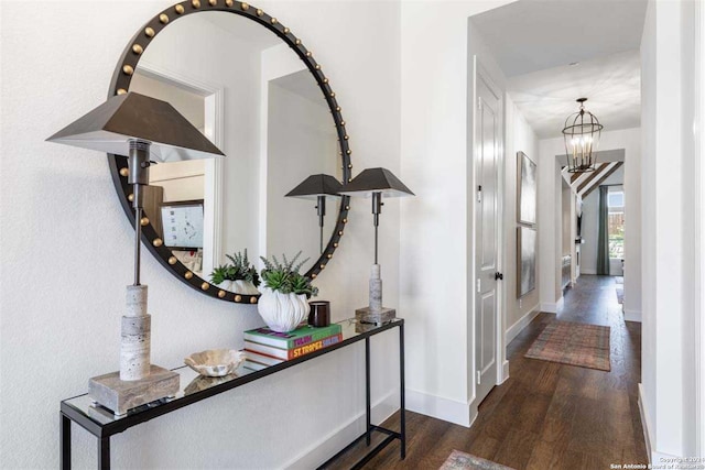 hall with dark hardwood / wood-style flooring and a chandelier