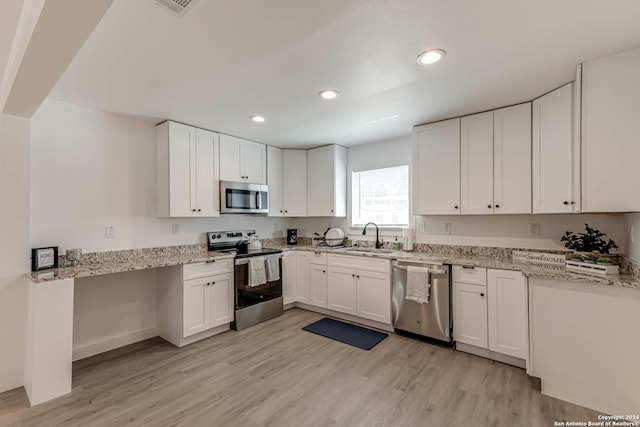 kitchen featuring white cabinetry, stainless steel appliances, and light wood-type flooring