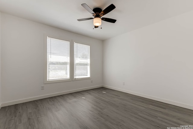 spare room with dark hardwood / wood-style floors and ceiling fan