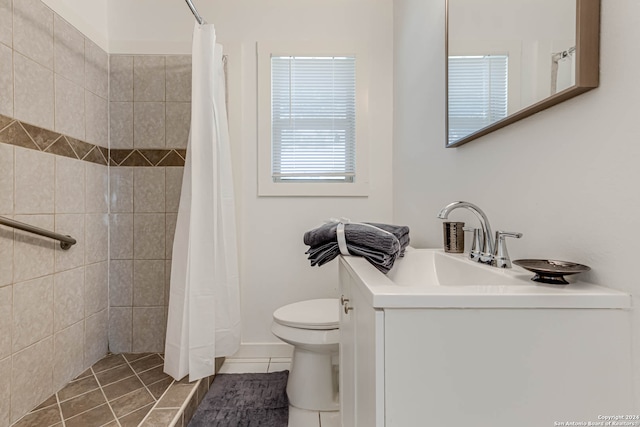 bathroom featuring toilet, walk in shower, vanity, and tile patterned floors