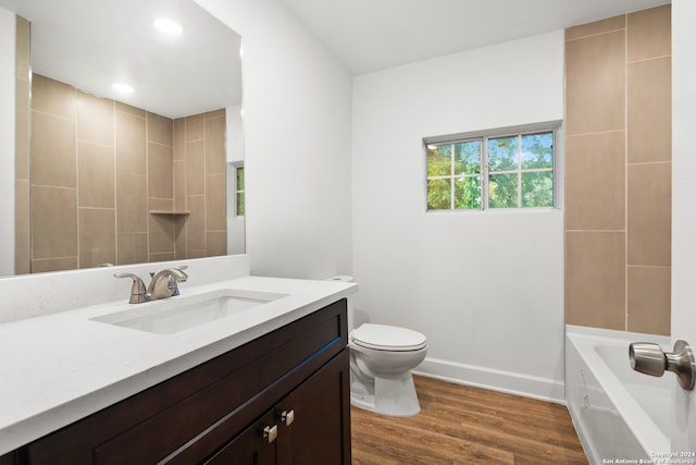 bathroom with toilet, hardwood / wood-style floors, and vanity