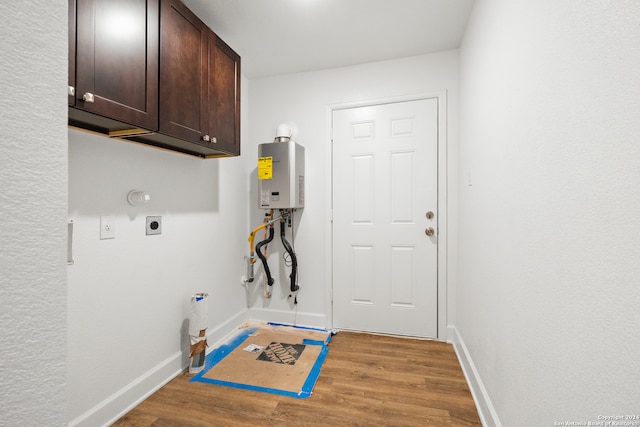 clothes washing area with electric dryer hookup, hookup for a gas dryer, light hardwood / wood-style flooring, and cabinets