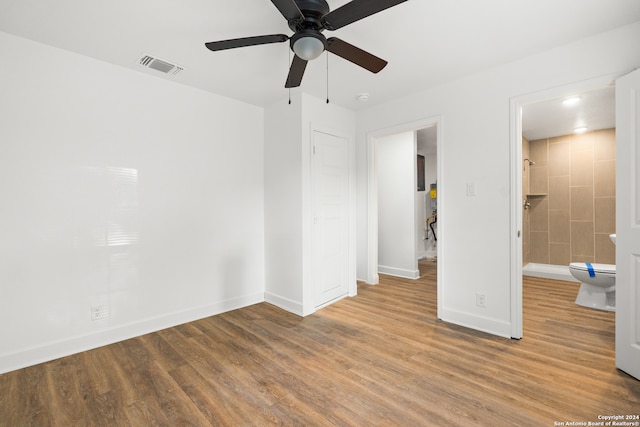 unfurnished bedroom with hardwood / wood-style floors, connected bathroom, and ceiling fan