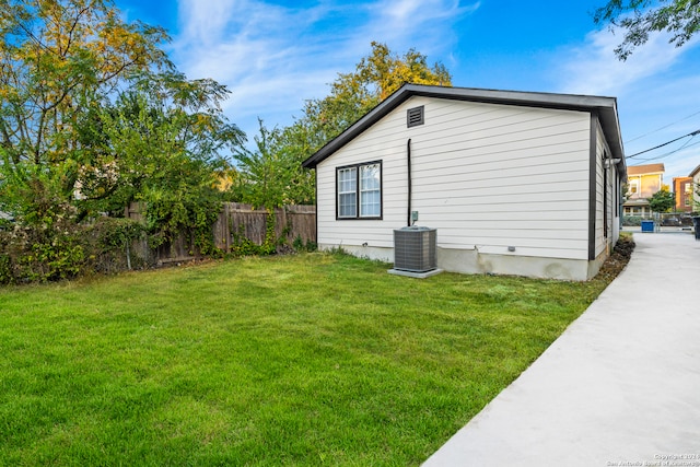 view of side of home featuring a lawn and central AC unit