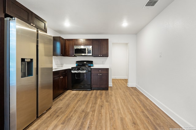 kitchen featuring dark brown cabinetry, stainless steel appliances, and light hardwood / wood-style floors