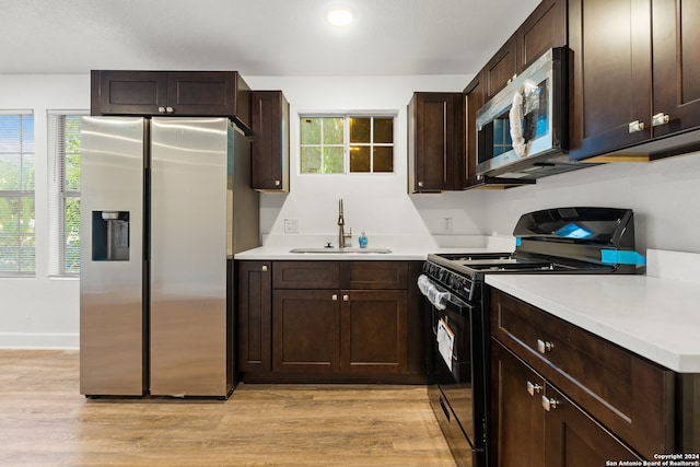 kitchen with stainless steel appliances, sink, plenty of natural light, and light wood-type flooring