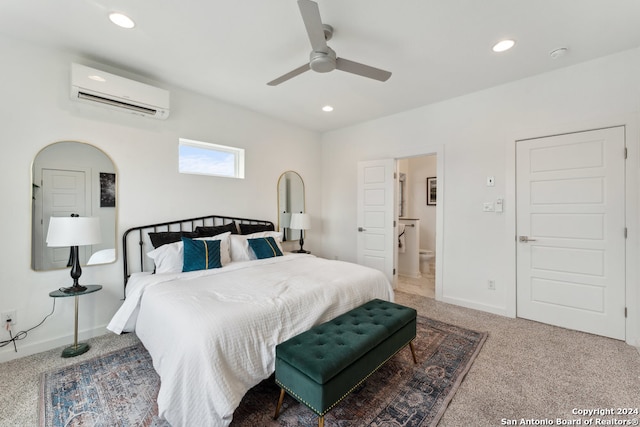 carpeted bedroom featuring ensuite bath, an AC wall unit, and ceiling fan