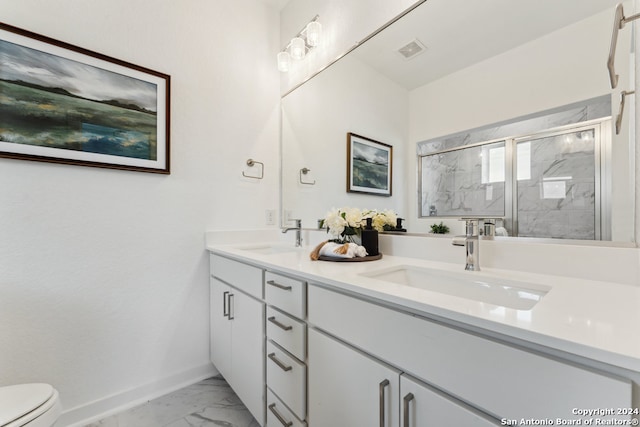 bathroom featuring vanity, a shower with shower door, and toilet