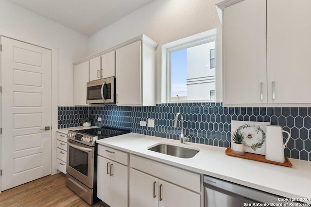 3216 N Elmendorf St, San Antonio, TX 78201 - kitchen featuring appliances with stainless steel finishes, a sink, light countertops, backsplash, and light wood-type flooring