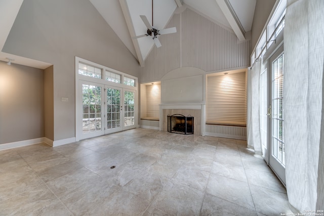 unfurnished living room featuring a wealth of natural light, high vaulted ceiling, and ceiling fan