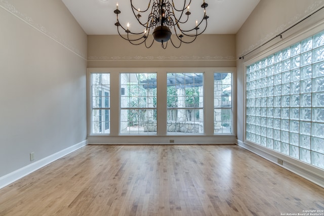 interior space with a chandelier, plenty of natural light, and light wood-type flooring