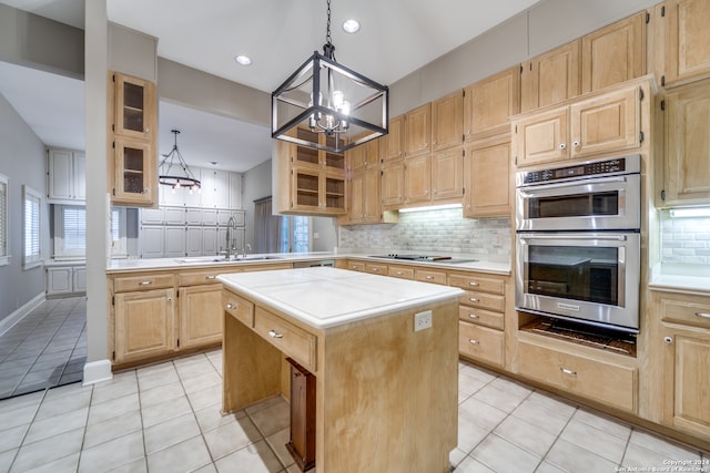 kitchen with light tile patterned floors, sink, a notable chandelier, a center island, and stainless steel double oven