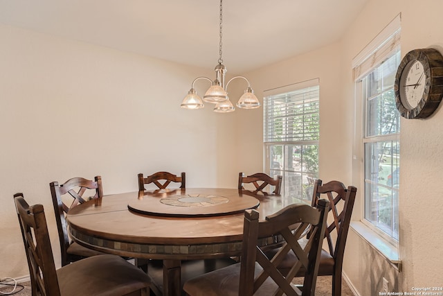 carpeted dining space with an inviting chandelier