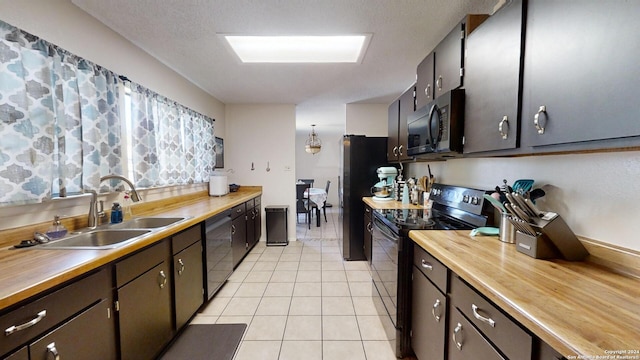 kitchen with wooden counters, sink, appliances with stainless steel finishes, and light tile patterned floors