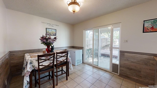 dining space featuring a textured ceiling and light tile patterned flooring