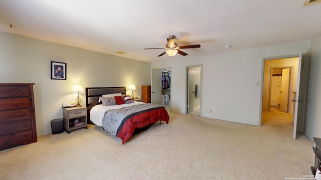 bedroom with light carpet, a closet, a spacious closet, and ceiling fan