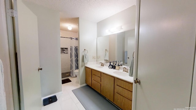 bathroom featuring vanity, toilet, a textured ceiling, and a tile shower