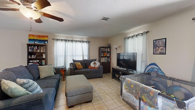 tiled living room featuring a textured ceiling and ceiling fan