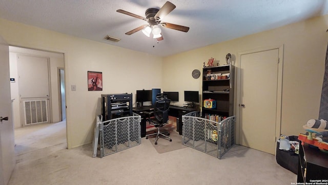 office featuring light carpet, a textured ceiling, and ceiling fan