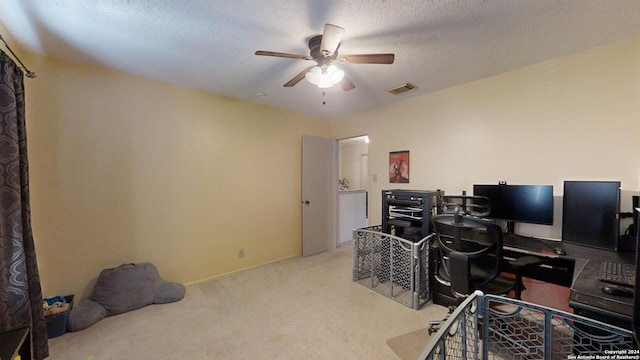 home office with light carpet, a textured ceiling, and ceiling fan