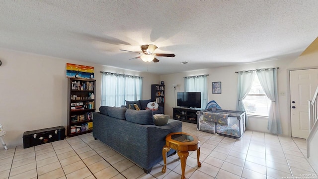 tiled living room featuring ceiling fan and a textured ceiling