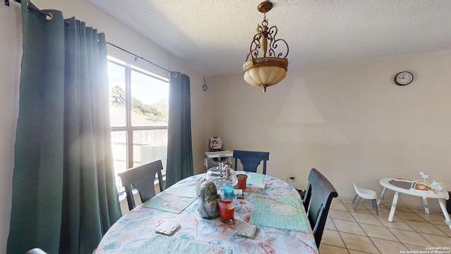 dining area featuring a textured ceiling and light tile patterned floors