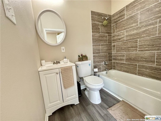 full bathroom with vanity, tiled shower / bath combo, hardwood / wood-style flooring, and toilet