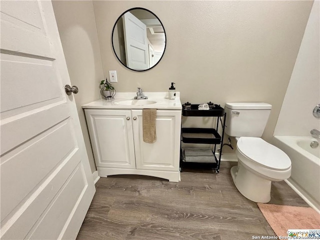 full bathroom with toilet, hardwood / wood-style floors, vanity, and  shower combination