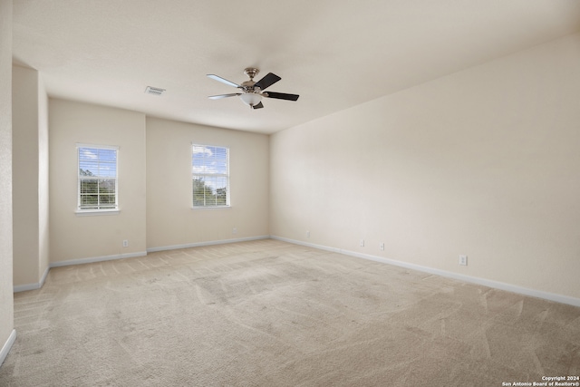 empty room with light colored carpet and ceiling fan