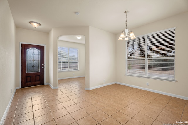 entrance foyer with a notable chandelier and light tile patterned floors