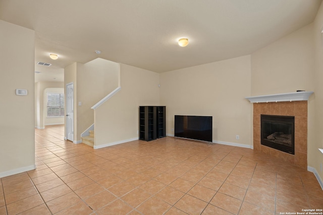 931 Palladio Pl, San Antonio, TX 78253 - unfurnished living room featuring light tile patterned flooring, a tiled fireplace, stairway, and baseboards