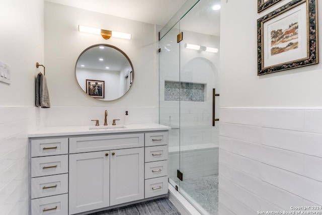 bathroom featuring vanity, tile walls, and a shower with shower door