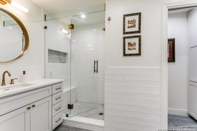 bathroom with vanity and a shower with door