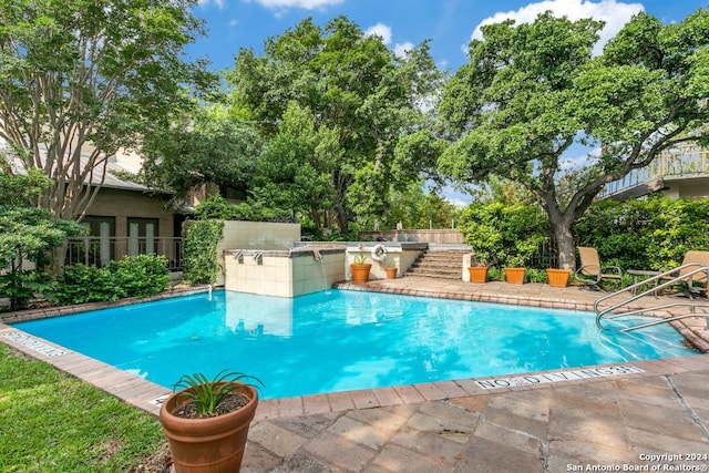 view of pool featuring a patio area and exterior kitchen