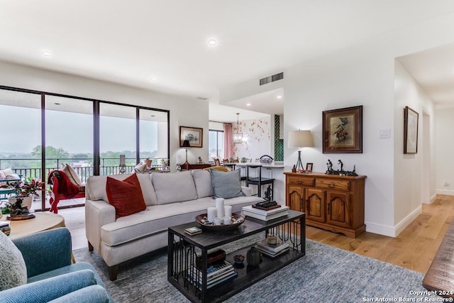 living room featuring light hardwood / wood-style floors and a notable chandelier