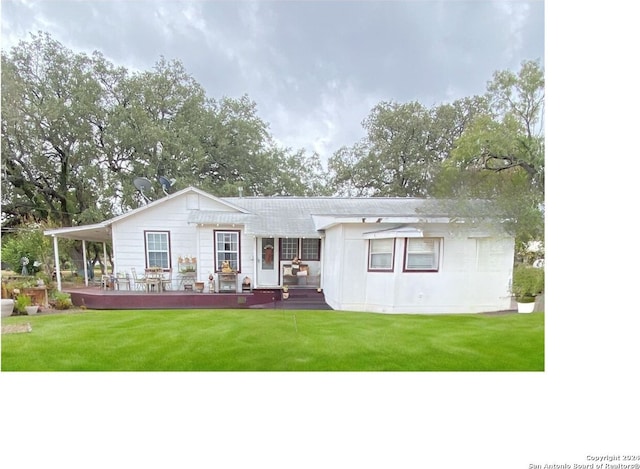 back of property featuring a deck and a yard