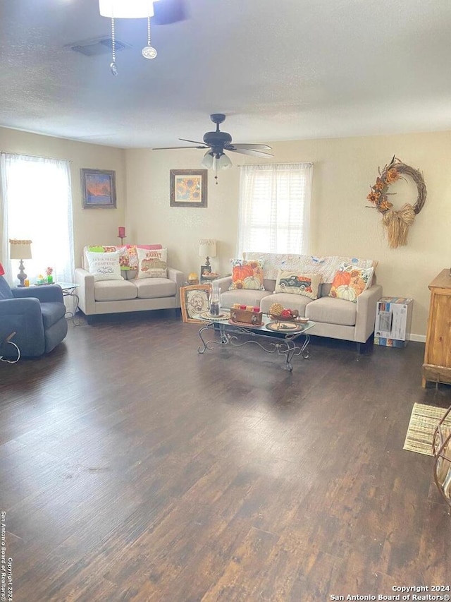 living room with ceiling fan and dark hardwood / wood-style flooring