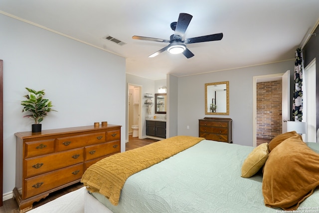 bedroom with connected bathroom, hardwood / wood-style floors, ornamental molding, and ceiling fan