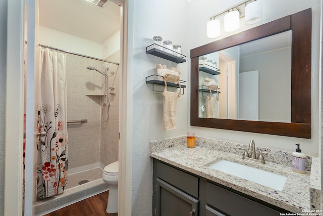 bathroom with curtained shower, hardwood / wood-style floors, toilet, vanity, and ornamental molding