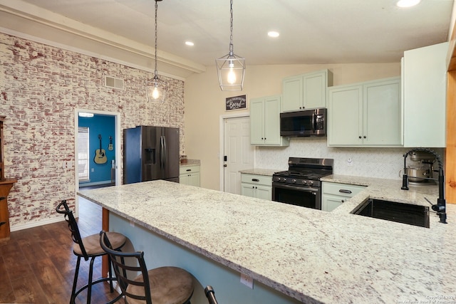 kitchen with light stone countertops, appliances with stainless steel finishes, sink, and a kitchen breakfast bar