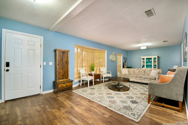 living room with a textured ceiling and hardwood / wood-style floors